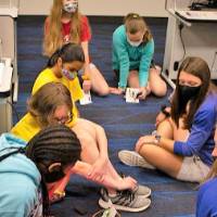 Campers sit on the ground testing projects